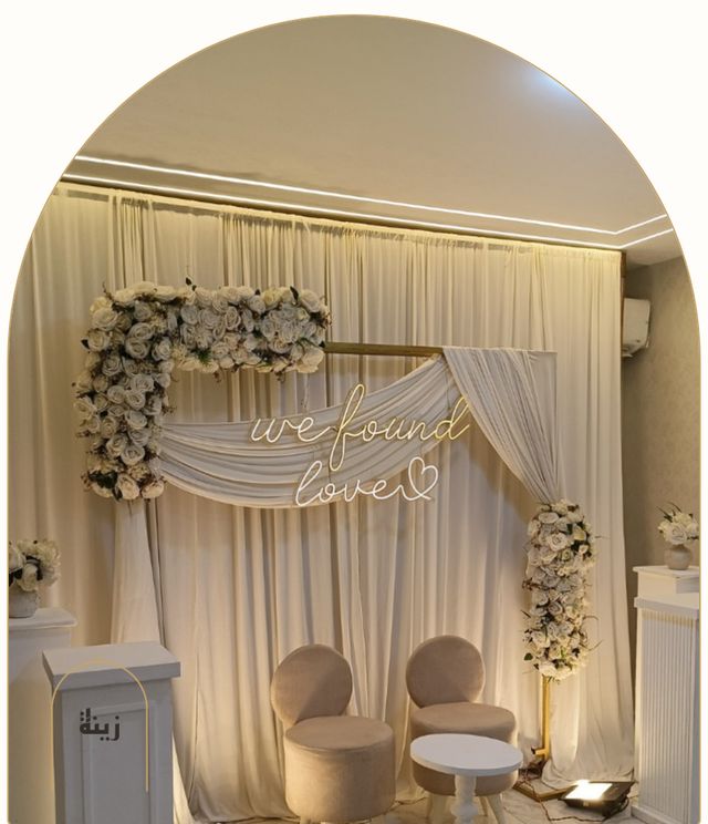 Drape-and-floral backdrop with warm lighting for an engagement — Zaina Events Abu Dhabi