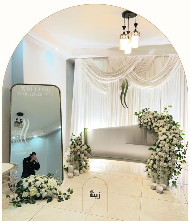 Indoor engagement setup with white drapes, florals and a couple’s sofa — Zaina Events Abu Dhabi