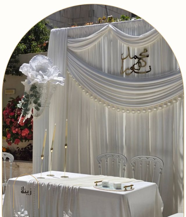 White drape backdrop with the couple’s names and candles for a katb ketab — Zaina Events Abu Dhabi