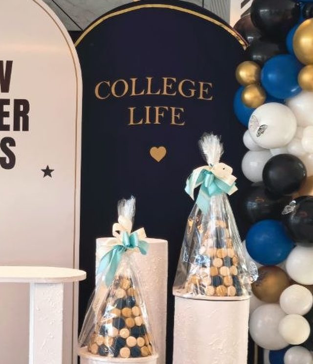 Guest favours in clear cones beside the College Life panel and a balloon column — Zaina Events Abu Dhabi