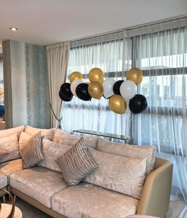 Guest lounge corner with a gold-and-black balloon bouquet by the windows — Zaina Events Abu Dhabi