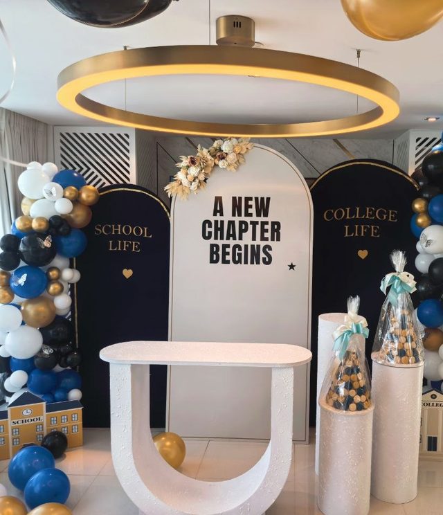 Side view of the college send-off stage with a gold ring chandelier and dried florals — Zaina Events Abu Dhabi