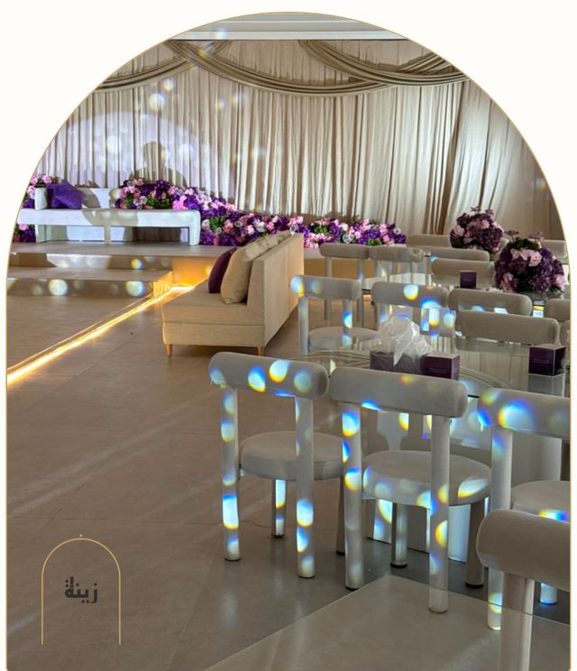 Guest seating with purple florals and theatrical lighting at a wedding — Zaina Events Abu Dhabi